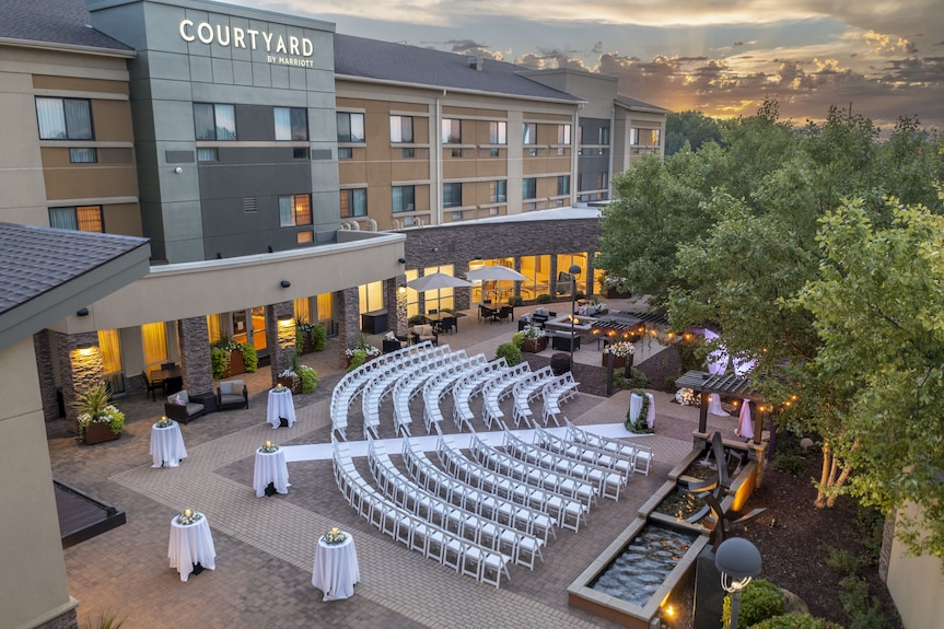 Aerial view of an outdoor courtyard wedding ceremony at dusk with the Courtyard by Marriott Mankato hotel