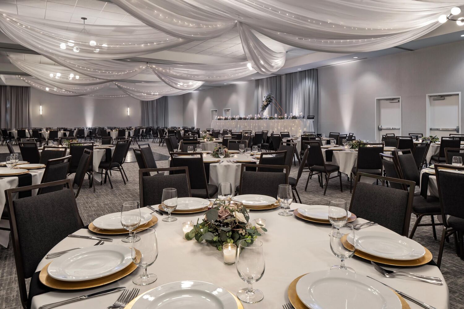 Event Center set with banquet rounds and candlelight for a wedding reception